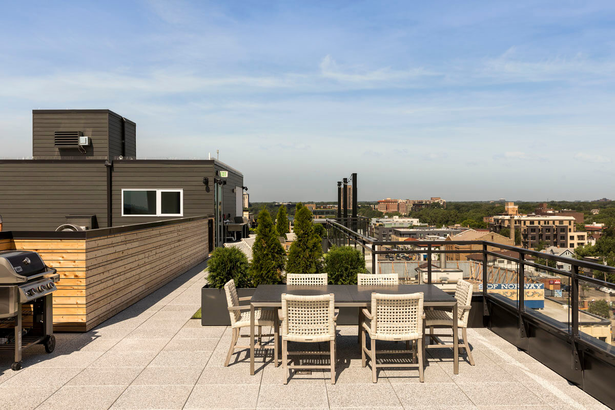 Rooftop entertainment area with seating and gas grill