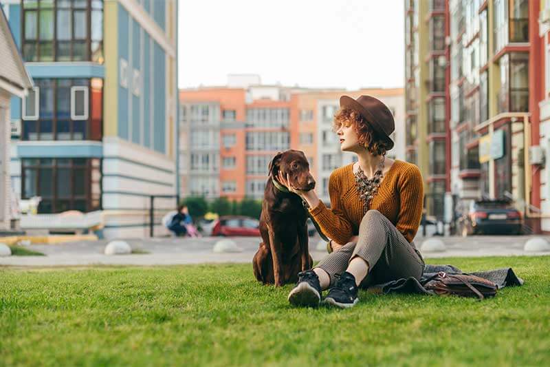 Photo of a woman and her dog in an urban greenspace setting