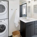 View of bathroom showing stacked washer-dryer